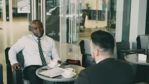 Commercial et client en réunion business devant un café . Sourires et postures détendues