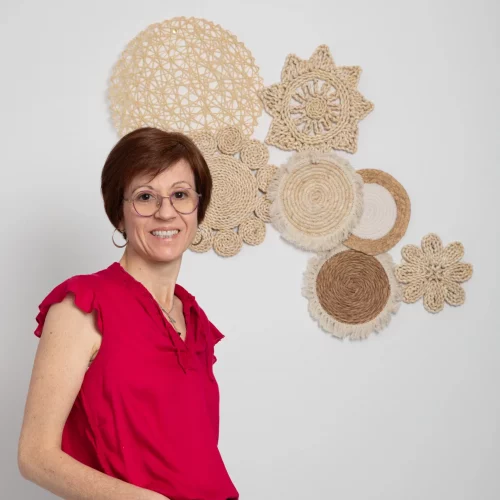 Valérie Perriguey de profil souriante devant une décoration murale liée à l’univers du bien-être